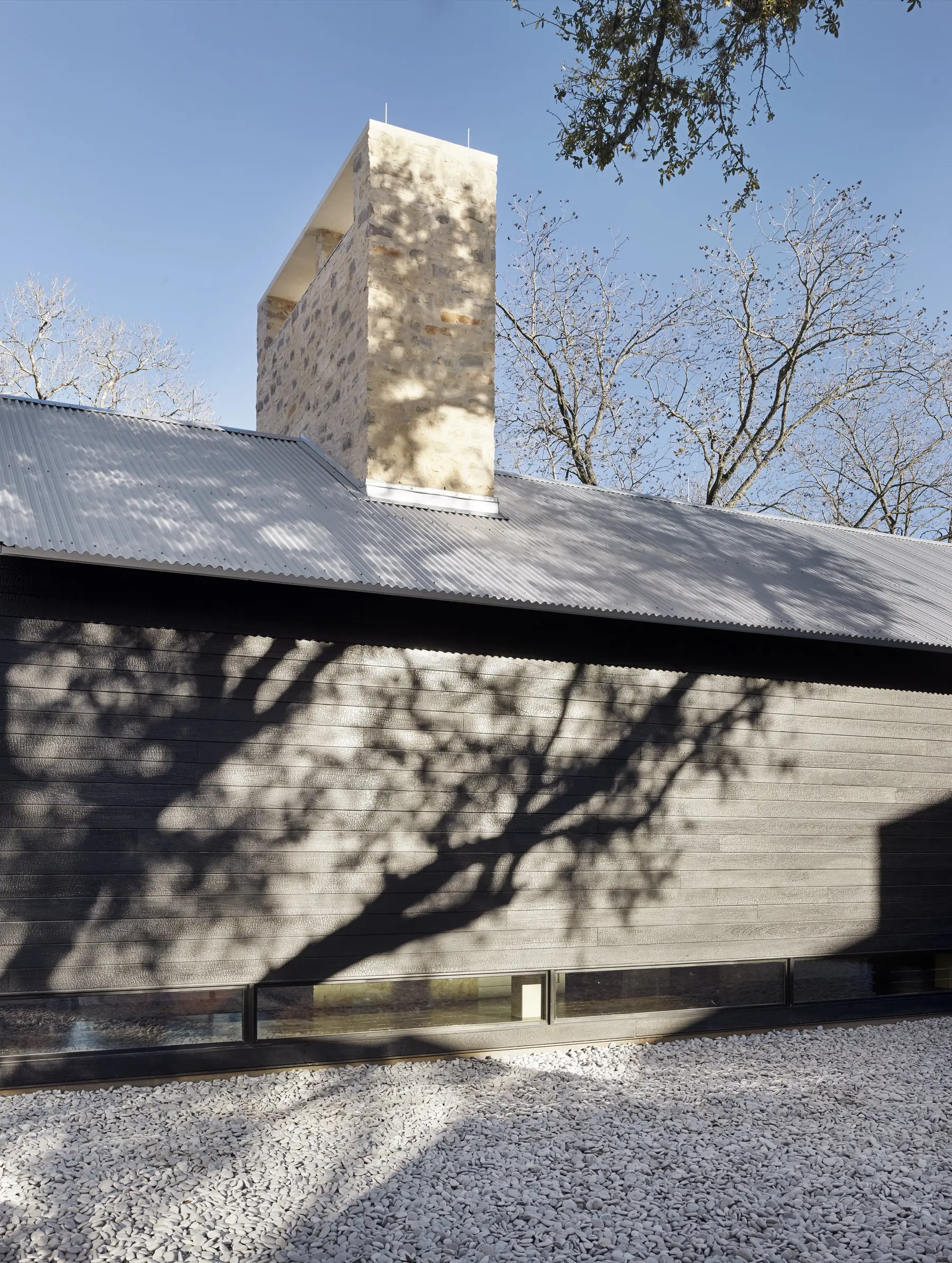 Exterior with siding and chimney, Modern Texas Prefab by Risinger Build, Austin, TX